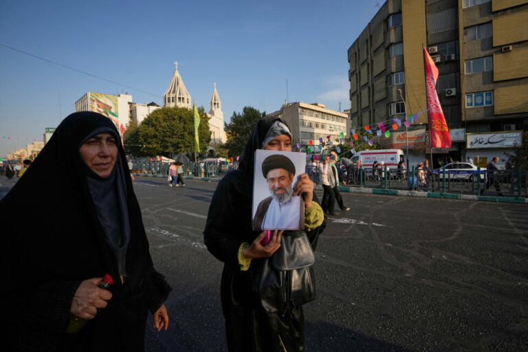 A government supporter holds a portrait of Iran's Supreme Leader Mojtaba Khamenei during a street celebration marking