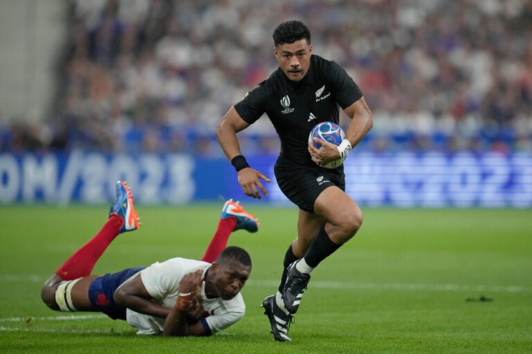 New Zealand's Richie Mo'unga runs with the ball after beating the tackle of France's Cameron Woki during the Rugby World Cup