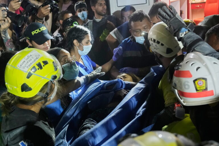 Rescue workers carry a survivor Daniela Largo after pulling her from the rubble the day after an earthquake struck Pereira