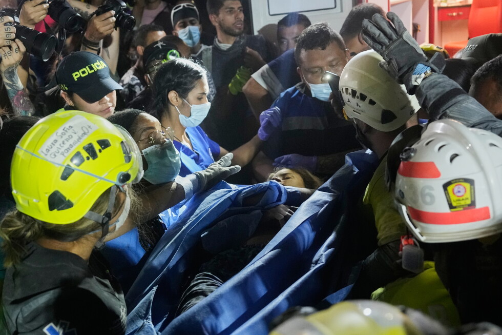 Rescue workers carry a survivor Daniela Largo after pulling her from the rubble the day after an earthquake struck Pereira
