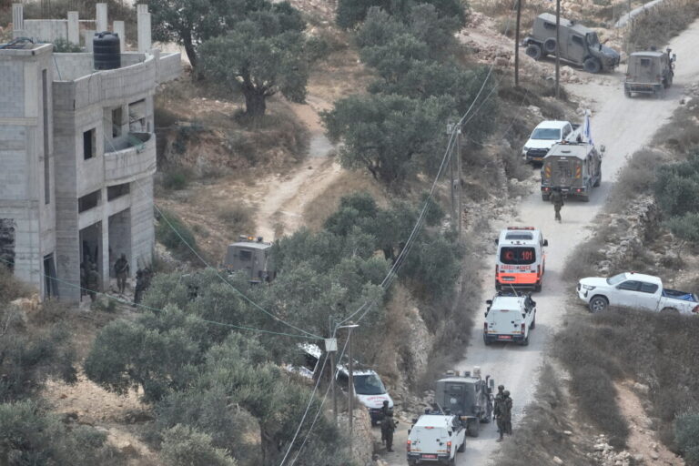 Israeli soldiers secure a building under construction as ambulances evacuate injured Palestinians following an attack by