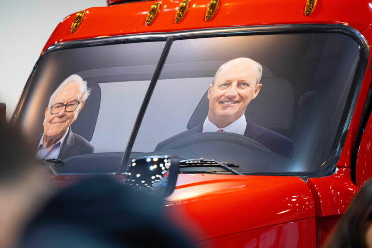 Portraits of Berkshire Hathaway's Warren Buffett, left, and CEO Greg Abel sit in a semi truck at the Pilot display in the
