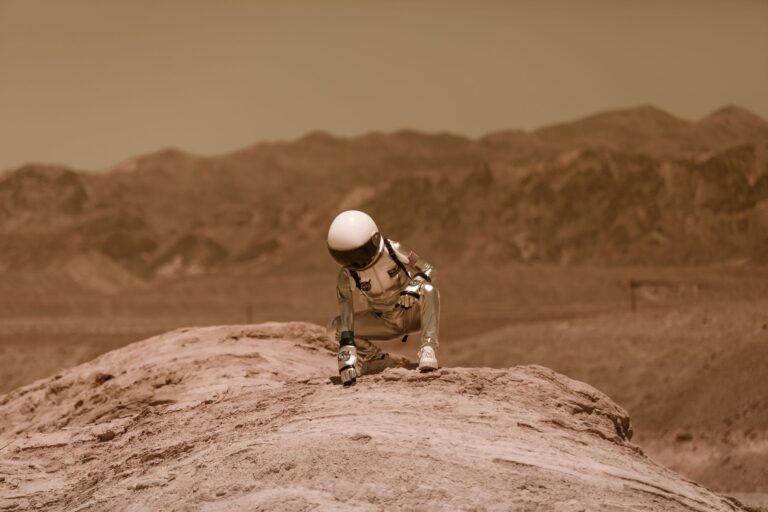 Representative staged image of an astronaut in a red desert landscape on Earth