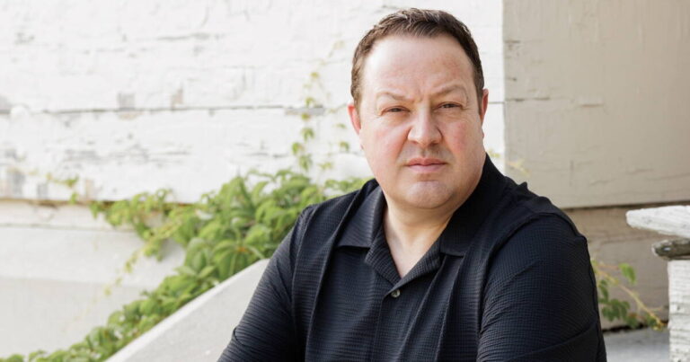 Author Dave Wedge standing with his arms crossed, facing the camera