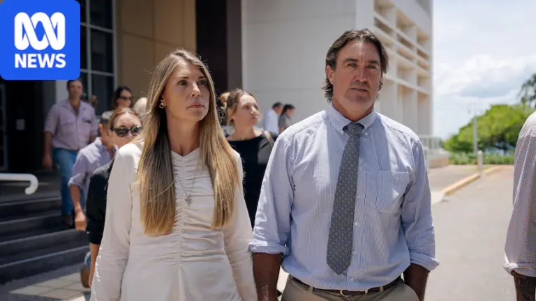 A woman with long blonde hair and a man with short dark hair hold hands as the leave the NT Supreme Court