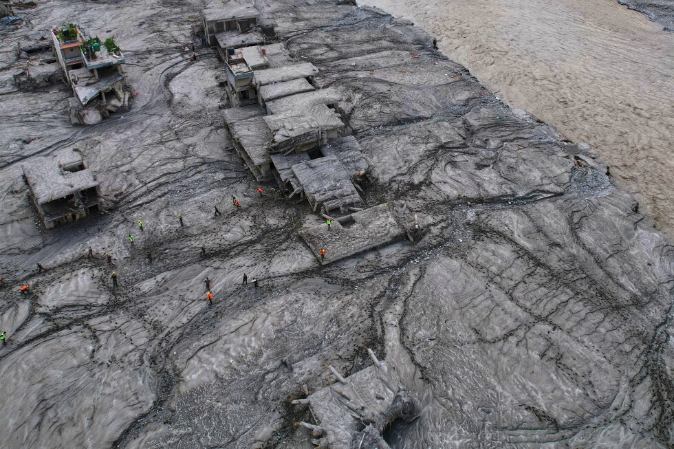 A drone view shows rescue workers inspect the area and damaged structures following recent flash flooding along the Trishuli