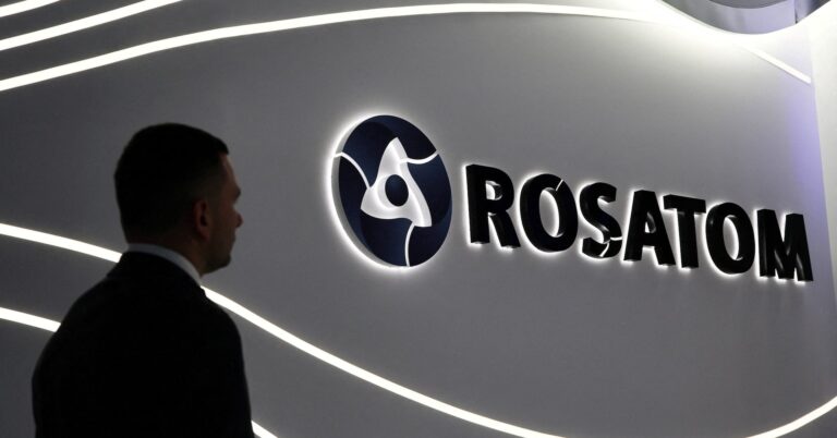 A man stands in front of an exhibition stand of Russia