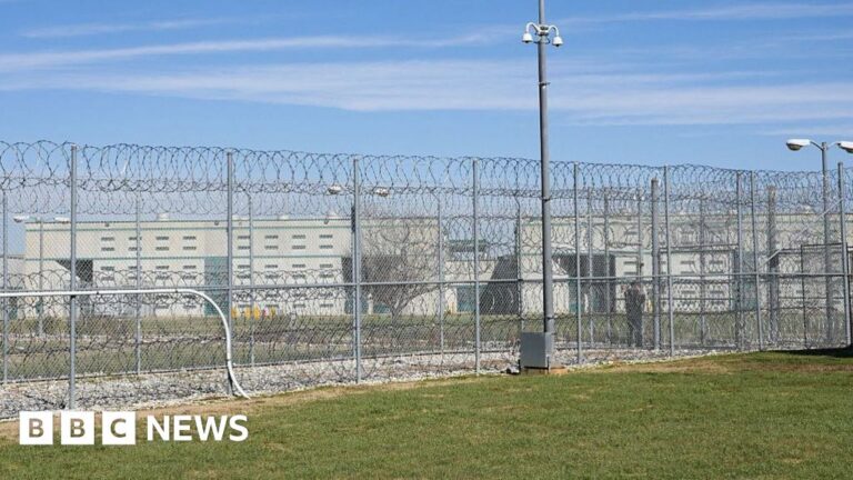 A fence, barbed wire and a guard are visible at the Allan B. Polunsky Unit, the prison that houses the men on Texas' death