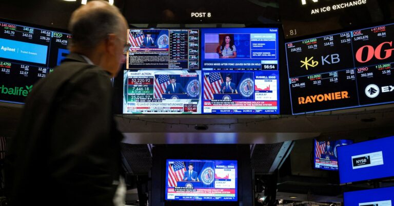 A trader works, as screens broadcast a press conference by U.S. Federal Reserve Chair Kevin Warsh following the Fed rate