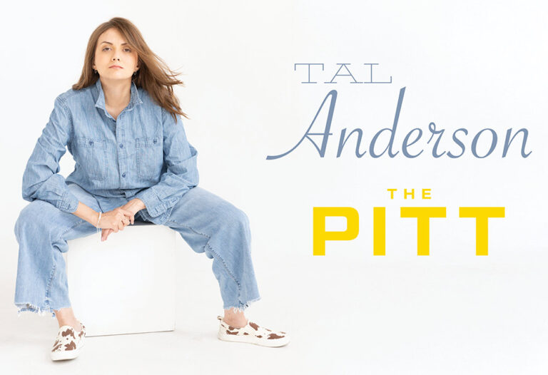 woman with long hair and denim outfit sits on a white box leaning forward next to name tal anderson from the pitt