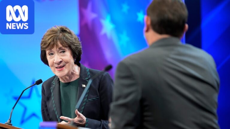 Susan Collins stands behind a debate podium and looks toward Troy Jackson