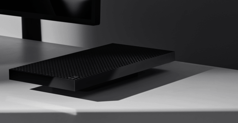 A Microsoft Surface RTX Spark Dev Box on a desk by a monitor